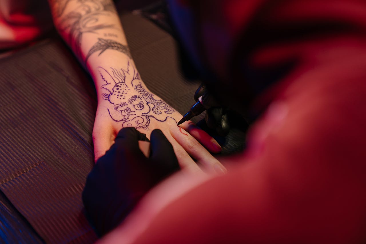 Person With Black Tattoo on Left Hand